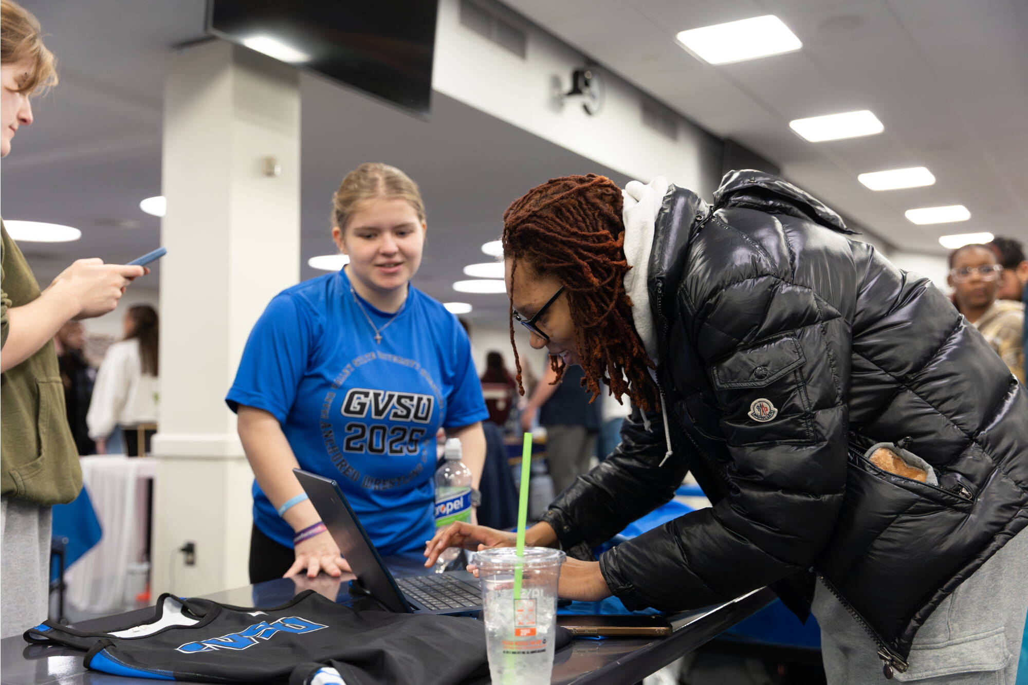 Wrestling club member helping a student sign up for their email list